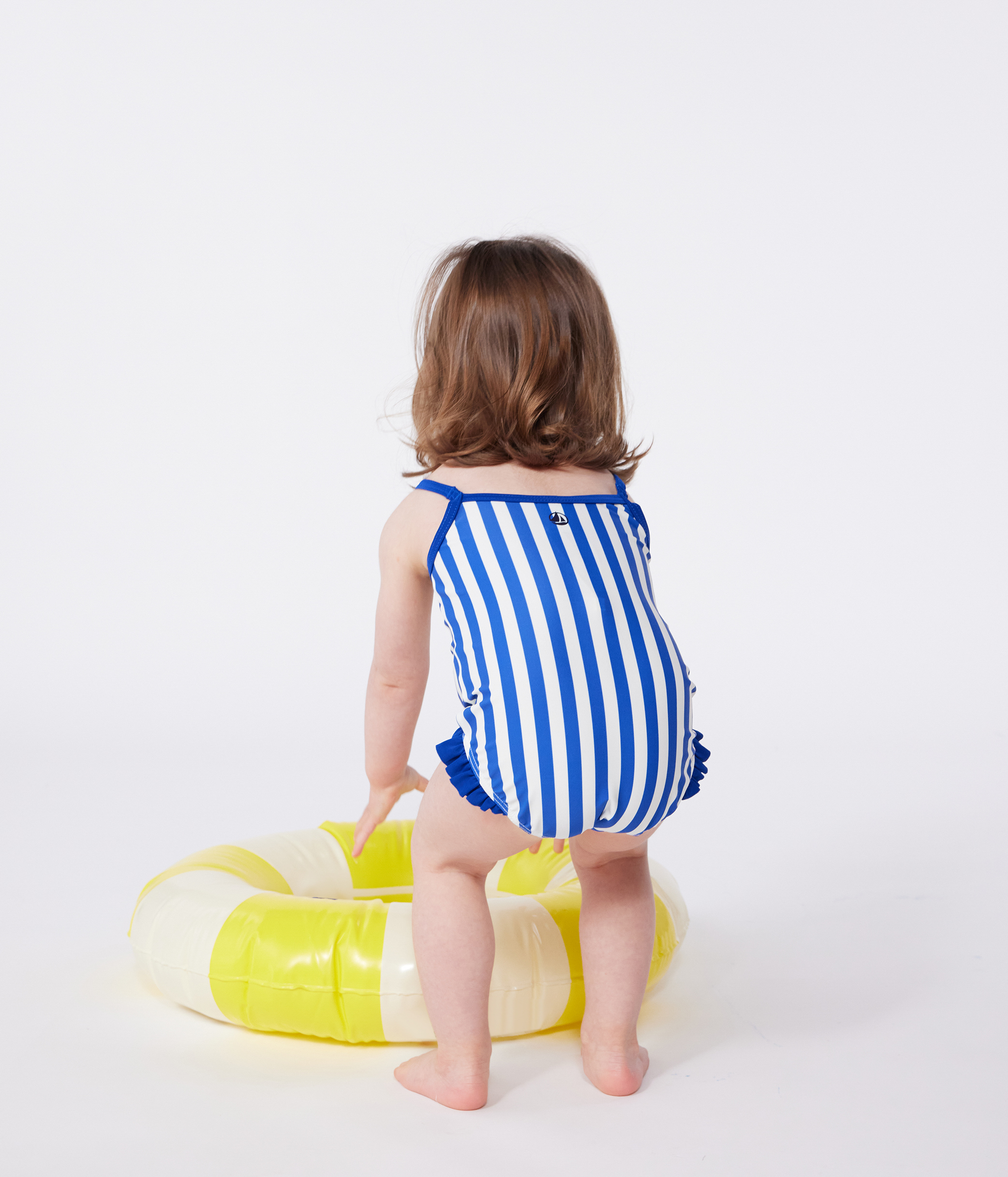Babies' one-piece swimsuit with frills and a stripy print.