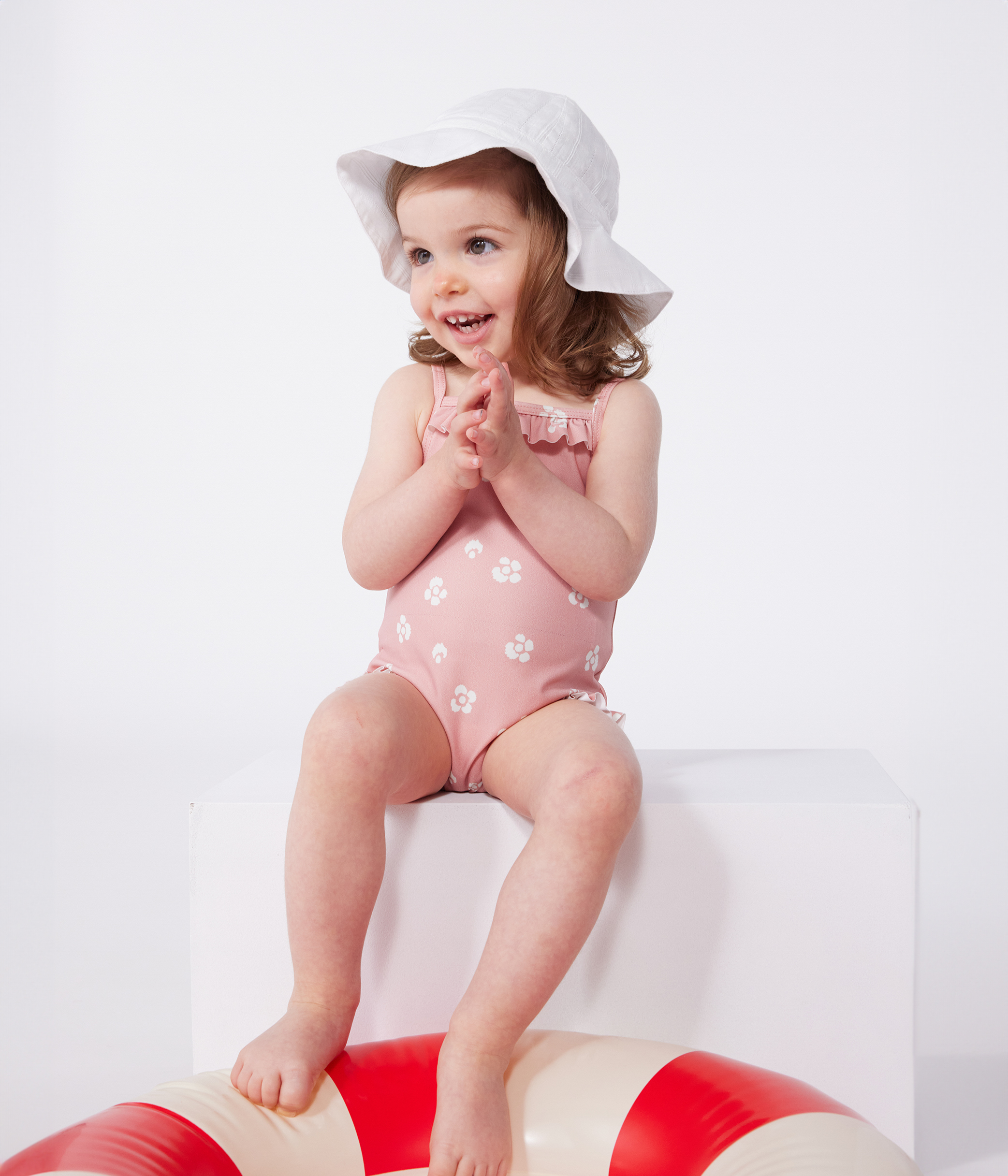 Babies' one-piece swimsuit with frills and a floral print.
