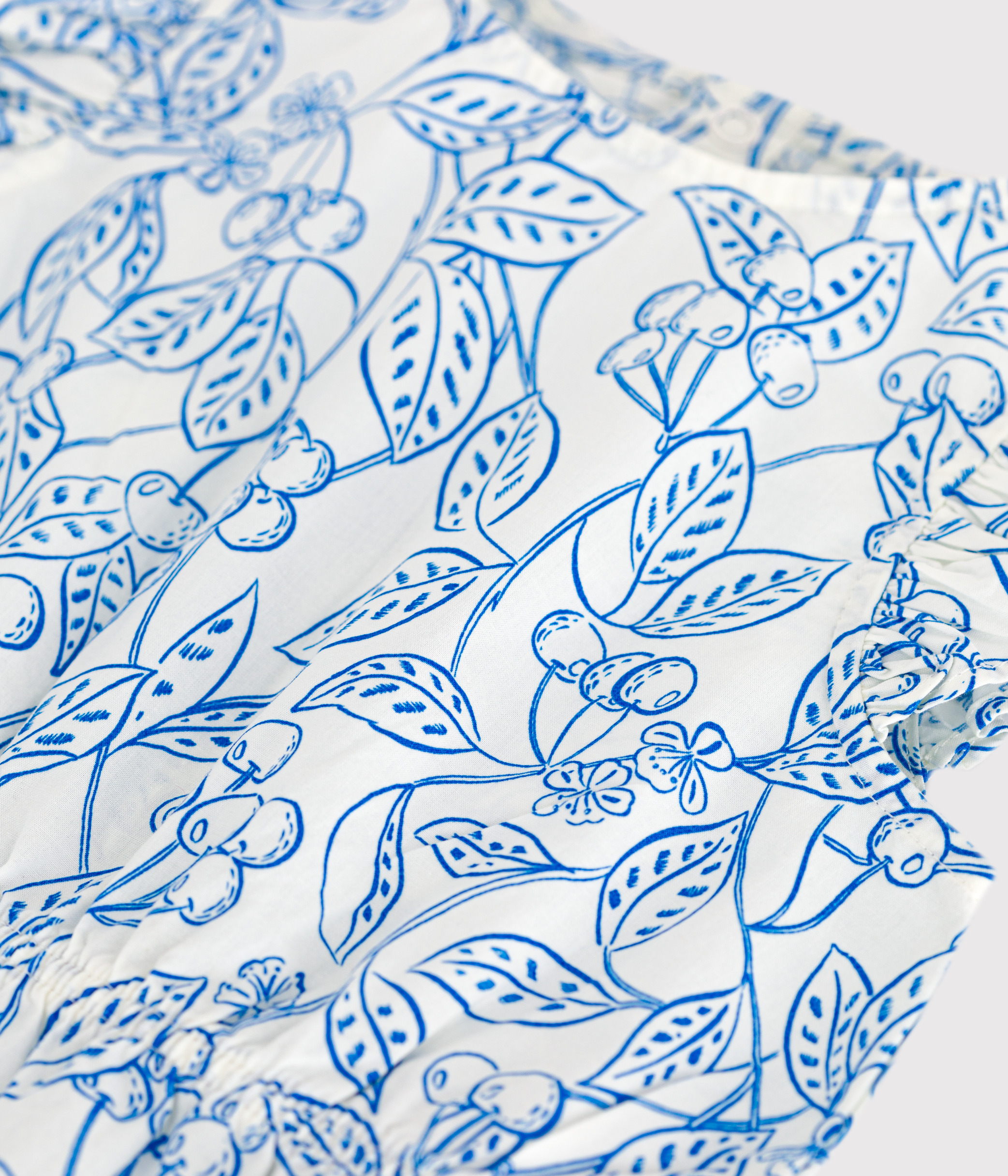 Babies' sleeveless playsuit in cotton with a blue cherry print