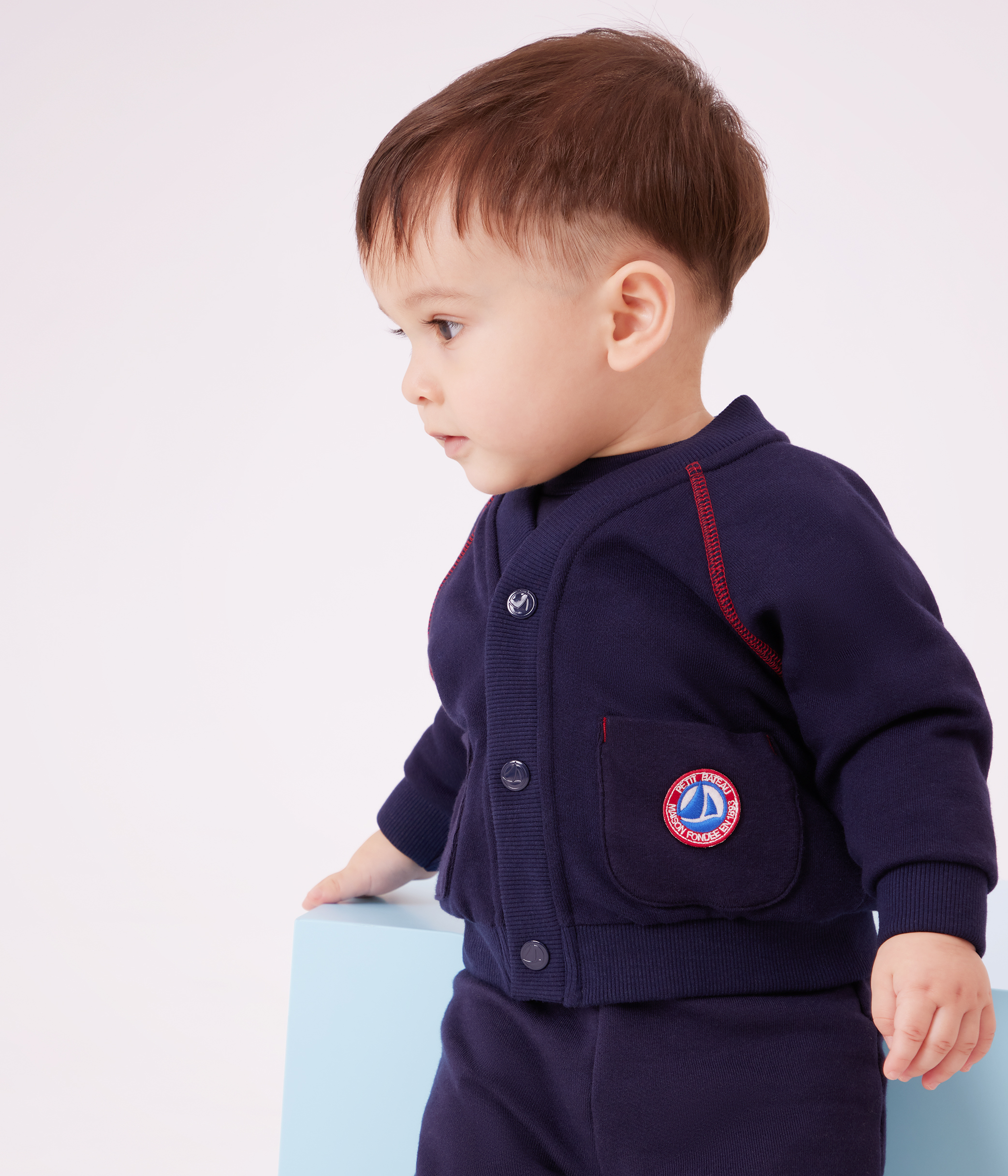 Babies' cardigan in plain cotton with contrasting stitching